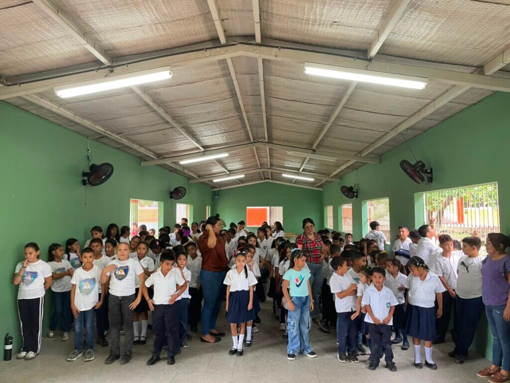 Equipo de Asuntos Corporativos de Azunosa junto a maestros y 250 estudiantes de la Escuela El Porvenir sosteniendo empaques de alimento MannaPack en Aldea El Bálsamo. Equipo de Asuntos Corporativos de Azunosa junto a maestros y 250 estudiantes de la Escuela El Porvenir sosteniendo empaques de alimento MannaPack en Aldea El Bálsamo.
