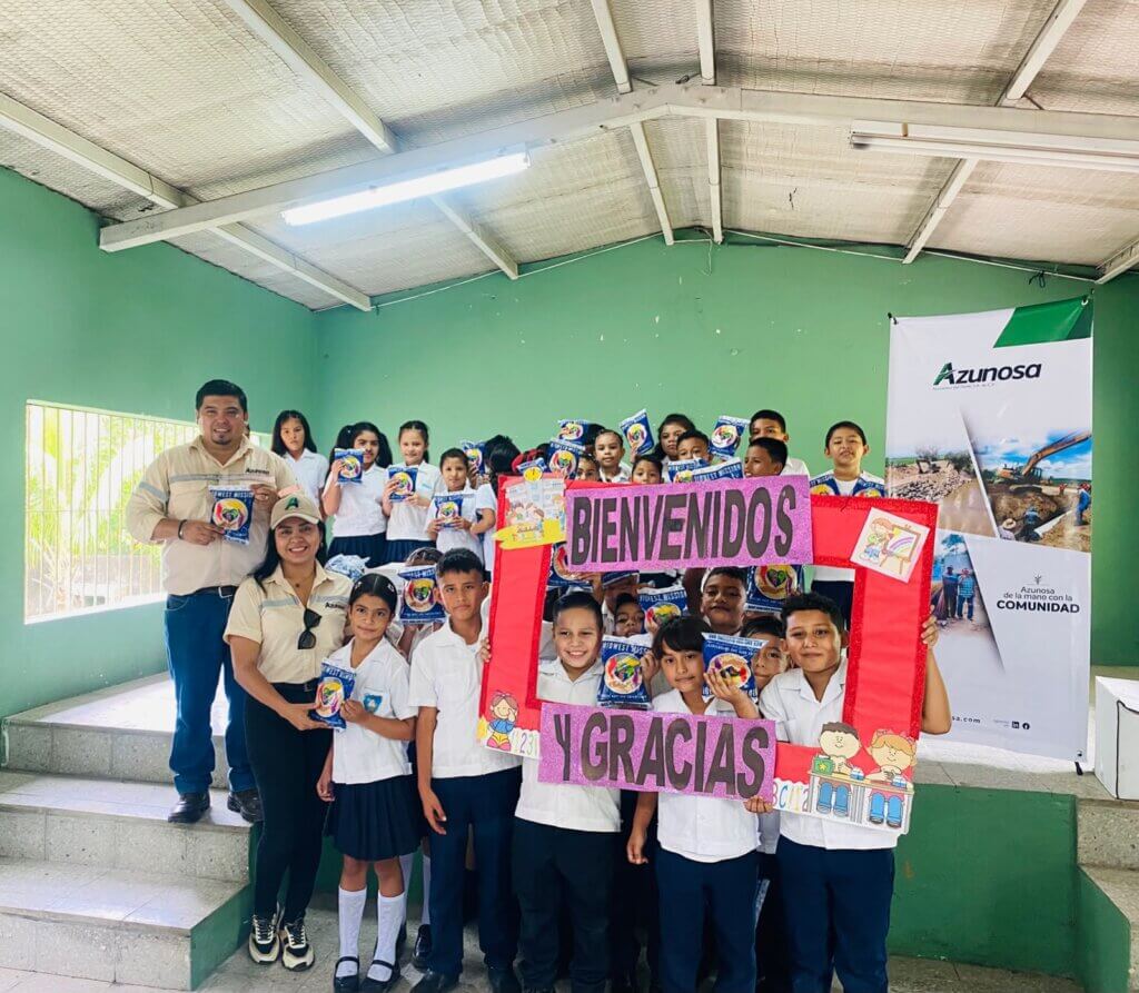 Equipo de Asuntos Corporativos de Azunosa junto a maestros y 250 estudiantes de la Escuela El Porvenir sosteniendo empaques de alimento MannaPack en Aldea El Bálsamo.