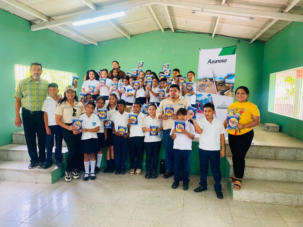 Equipo de Asuntos Corporativos de Azunosa junto a maestros y 250 estudiantes de la Escuela El Porvenir sosteniendo empaques de alimento MannaPack en Aldea El Bálsamo.